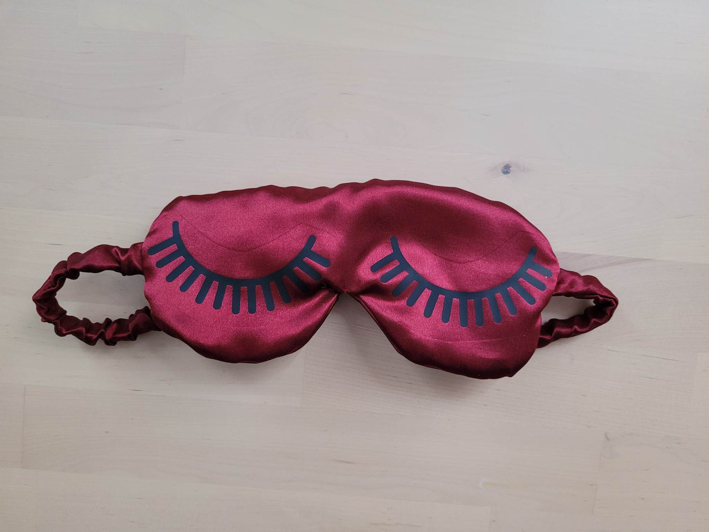 Masque de nuit en satin rouge bordeaux.