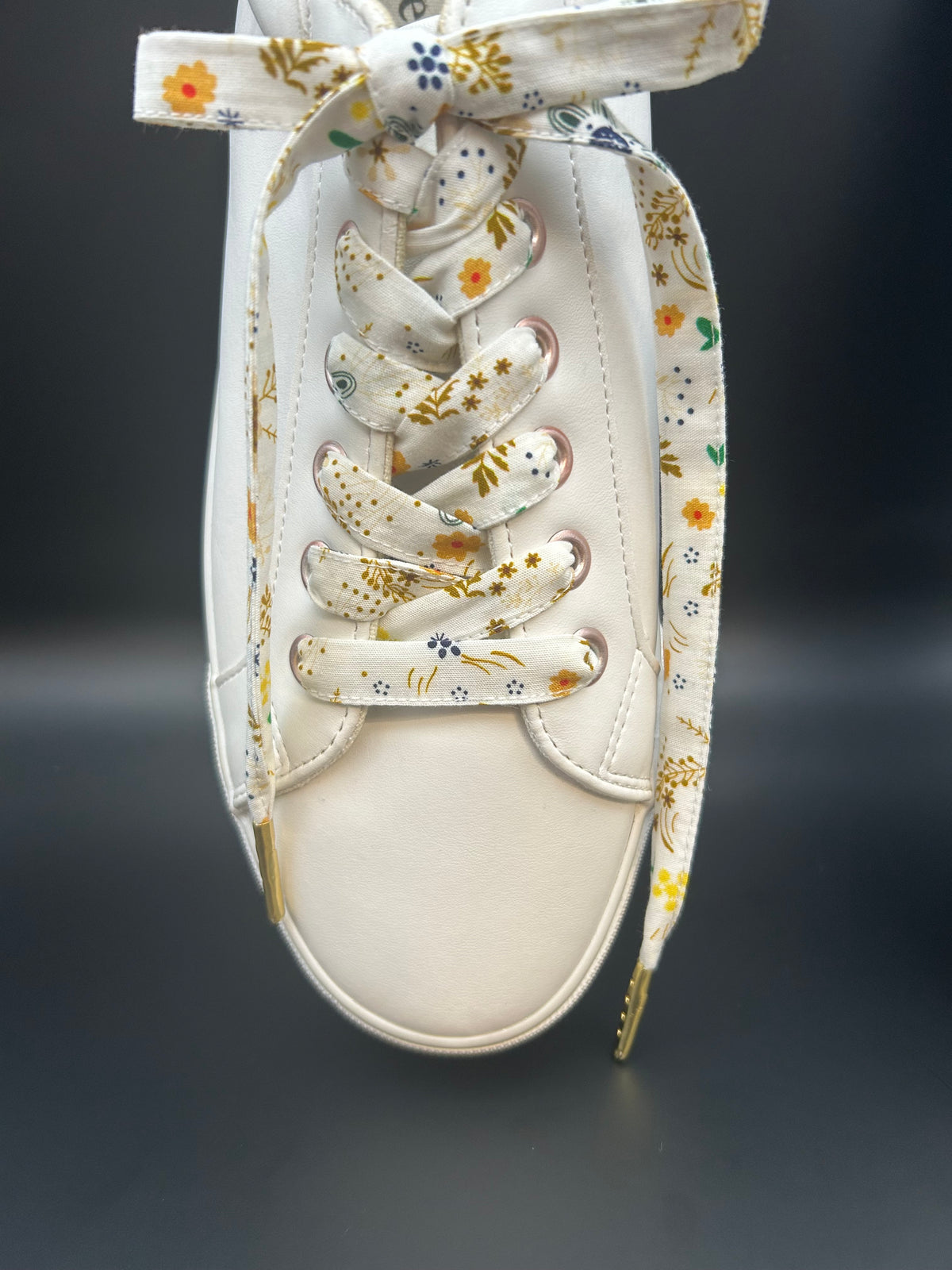 Lacets fleuris en tissu sur baskets blanches
