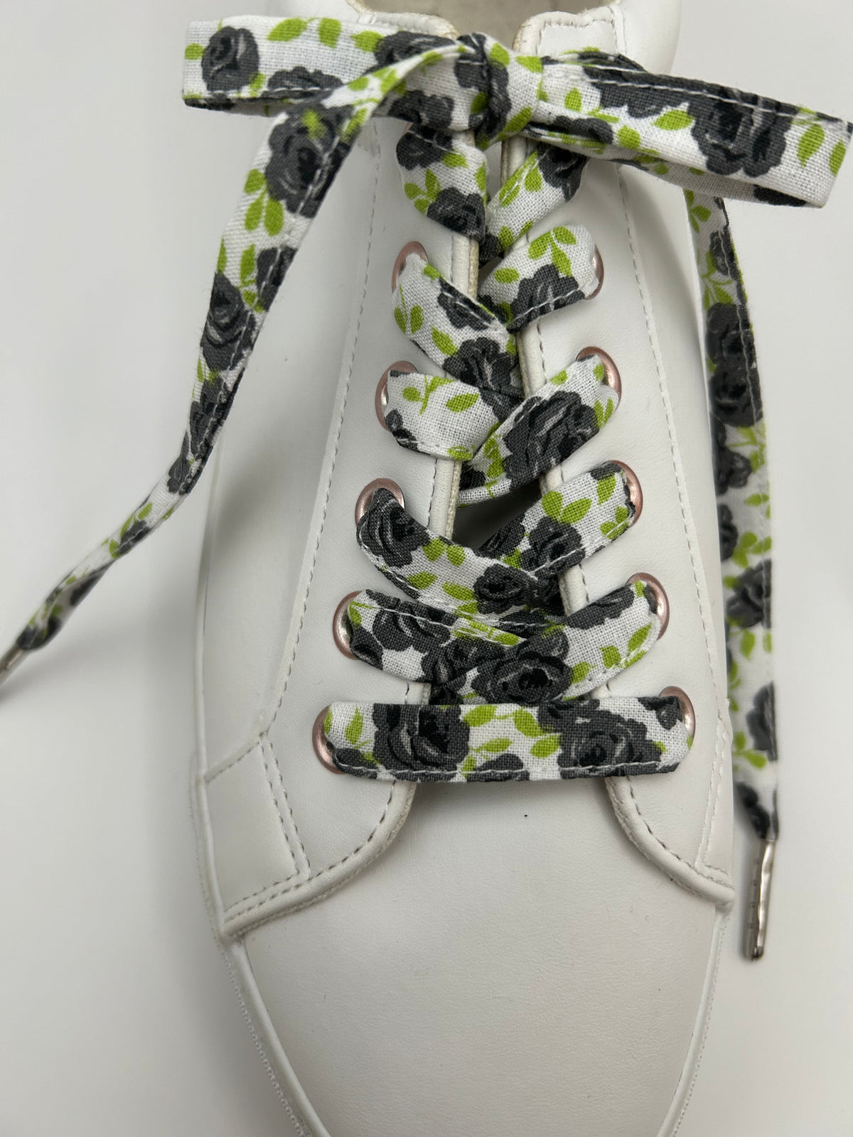 Lacets blancs à roses noires et feuillage vert